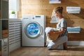 Happy housewife woman in laundry room with washing machine Royalty Free Stock Photo