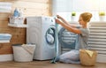 Happy housewife woman in laundry room with washing machine