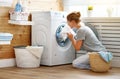 Happy housewife woman in laundry room with washing machine