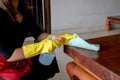 The happy housewives in rubber gloves wipe the dust with a spray while cleaning the tables and chairs cleaning concept