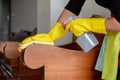 The happy housewives in rubber gloves wipe the dust with a spray while cleaning the tables and chairs cleaning concept