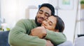 Happy, hug and couple on a sofa with love, relax and security at home bonding, hanging out or chilling. Smile, support Royalty Free Stock Photo