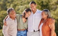 Happy, hug and smile, an adult family in a park standing together. Mother, father grown up kids laughing. Happiness