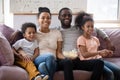 Happy hugging african family with children watching tv movie together Royalty Free Stock Photo