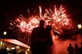 Happy hugging bride and groom watching beautiful colorful fireworks night sky