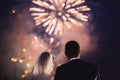 Happy hugging bride and groom watching beautiful colorful fireworks night sky.