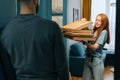 Happy hunger young woman open box of hot pizza standing at entryway on apartment, looking inside. Royalty Free Stock Photo