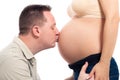 Happy husband kissing pregnant belly