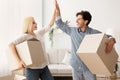 Happy Husband And Wife Giving High Five Holding Moving Boxes