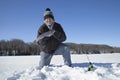 Happy ice fisherman holds up freshly caught rainbow trout on a northern Minnesota lake