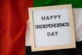 HAPPY INDEPENDENCE DAY text frame on United Arab Emirates waving flag made from silk material. Commemoration Day Muslim Royalty Free Stock Photo