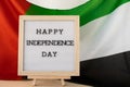 HAPPY INDEPENDENCE DAY text frame on United Arab Emirates waving flag made from silk material. Commemoration Day Muslim Royalty Free Stock Photo