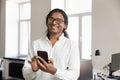 Happy Indian business leader man in glasses holding mobile phone Royalty Free Stock Photo