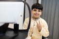 Happy Indian child boy examining eyesight modern ophthalmology equipment in clinic. Patient kid male scan checkup iris examines Royalty Free Stock Photo