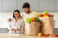 Happy indian couple with bag full of food checking bill Royalty Free Stock Photo