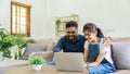 Happy indian Couple Using Laptop Browsing Internet Together on sofa at home Royalty Free Stock Photo