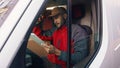 Happy indian courier using tablet in the van