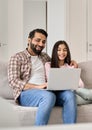 Happy indian dad with teenage daughter having fun using laptop at home. Royalty Free Stock Photo