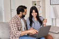 Happy indian couple shoppers doing online shopping using credit card and laptop.