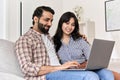 Happy indian family couple using laptop computer together at home. Royalty Free Stock Photo