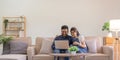 Happy indian family couple using laptop looking at computer laptop sitting on sofa together relaxing at home Royalty Free Stock Photo