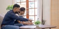 Happy indian family couple using laptop looking at computer laptop sitting on sofa together relaxing at home Royalty Free Stock Photo