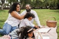 Happy indian family having fun painting with children outdoor at city park - Main focus on father face Royalty Free Stock Photo