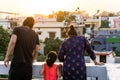 Happy Indian family, parents and daughter, gazing outside from rooftop of their home. A beautiful moment of togetherness and love