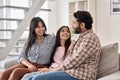Happy indian family with teen child daughter talking sitting on couch at home.