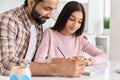 Happy indian father helping school kid teen daughter learning at home. Royalty Free Stock Photo