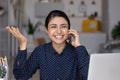 Happy Indian girl speaking on cellphone at laptop Royalty Free Stock Photo