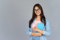 Happy indian girl student in glasses hold book isolate grey background portrait