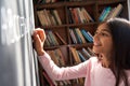 Happy indian latin kid school girl pupil holding chalk writing on blackboard. Royalty Free Stock Photo