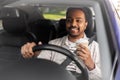 happy indian man or driver with coffee driving car
