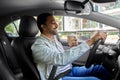 happy indian man or driver with coffee driving car