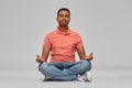 Happy indian mant meditating in lotus yoga pose