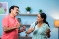 Happy indian senior couple dancing and singing by holding cooking spoons at home - concept of active retirement Royalty Free Stock Photo