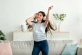 Happy Indian teenage girl with headphones dancing to beautiful music at home Royalty Free Stock Photo