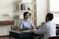 Happy Indian woman consulting young male doctor at appointment