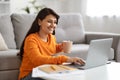 Happy indian woman freelancer working on laptop, home interior Royalty Free Stock Photo