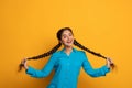 Happy indian woman holding and pulling her two long braids