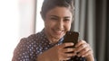 Happy indian woman holding smartphone looking at screen reading message Royalty Free Stock Photo