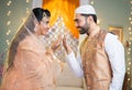 Happy indina muslim couple celebarting eid or ramadan by wishing each other at home - concept of islamic festival