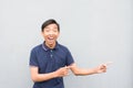 Happy Indonesian guy pointing his index fingers to the right on a white background