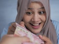 Happy Indonesian Muslim Woman Receiving Rupiah Money