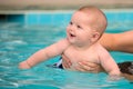 Happy infant baby boy enjoying his first swim