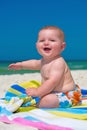 Happy infant baby boy sitting on towel at the beach Royalty Free Stock Photo