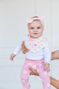 Happy infant baby girl being held up in the air by her parent. Smiling cute baby 6 months old Royalty Free Stock Photo