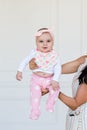 Happy infant baby girl being held up in the air by her parent. Smiling cute baby 6 months old Royalty Free Stock Photo