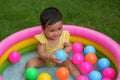 happy infant baby girl playing water with colorful plastic balls in inflatable pool Royalty Free Stock Photo